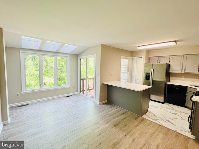 6062 Clay Spur Ct, Centreville, VA 20121 - kitchen with stainless steel refrigerator with ice dispenser, light countertops, light wood-type flooring, vaulted ceiling, and a skylight