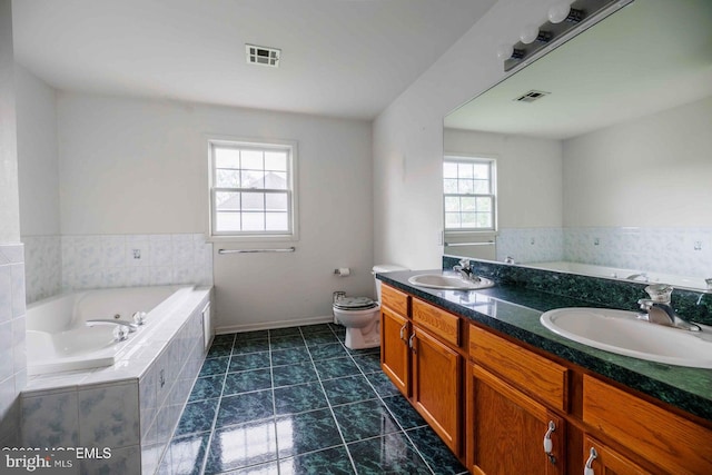 full bath featuring a sink, toilet, a bath, and visible vents