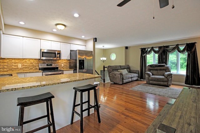 19 Old Hilltop Rd, Conowingo, MD 21918 - kitchen featuring light stone countertops, white cabinetry, open floor plan, backsplash, and appliances with stainless steel finishes