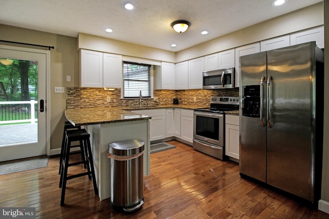 19 Old Hilltop Rd, Conowingo, MD 21918 - kitchen with a peninsula, white cabinetry, dark wood-type flooring, and appliances with stainless steel finishes
