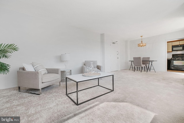 carpeted living area with a chandelier