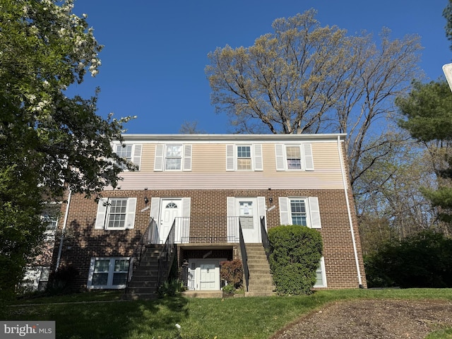 view of front of home featuring brick siding and a front yard