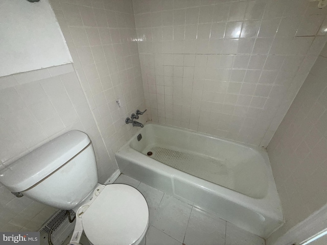 bathroom featuring toilet and tile walls