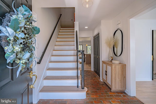 stairway featuring recessed lighting, baseboards, and brick floor