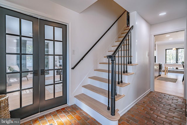 stairway with recessed lighting, baseboards, french doors, and brick floor