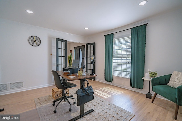 office with crown molding, baseboards, visible vents, and wood finished floors