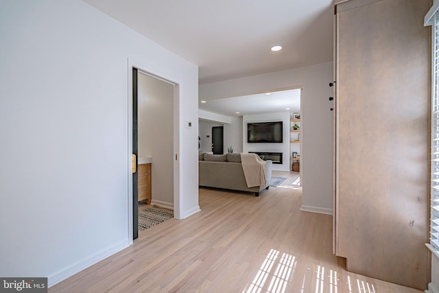 hall featuring recessed lighting, baseboards, and light wood finished floors