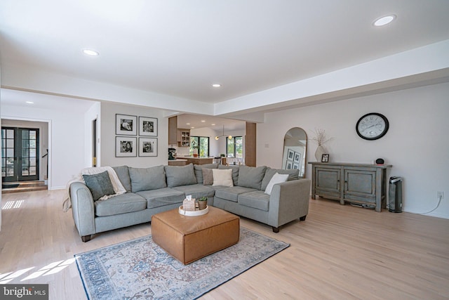 living room with arched walkways, recessed lighting, and light wood-type flooring