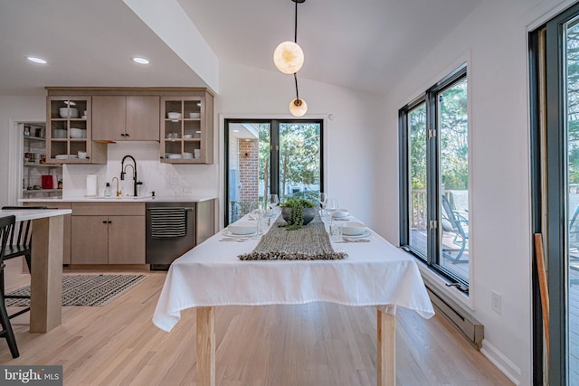 kitchen featuring light countertops, a baseboard heating unit, a wealth of natural light, and light wood finished floors