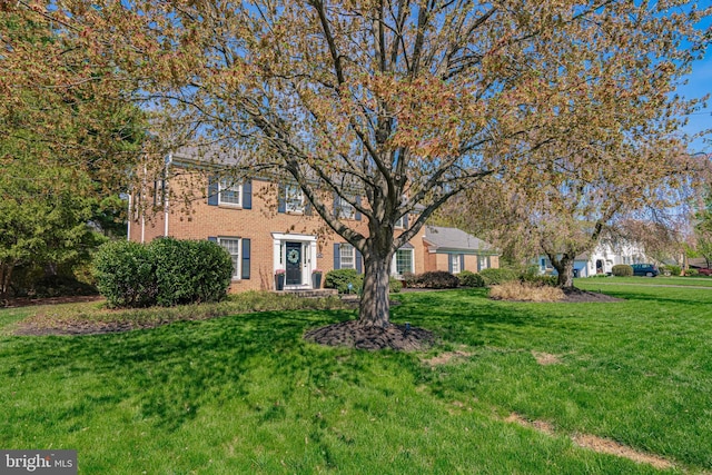 view of front facade with a front lawn and brick siding