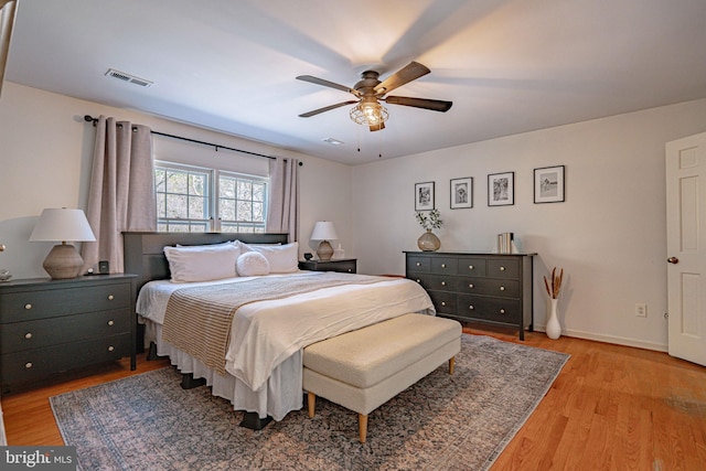 bedroom featuring visible vents, light wood-style flooring, ceiling fan, and baseboards