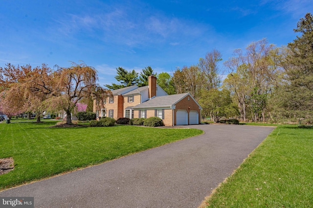 view of home's exterior featuring a yard, an attached garage, driveway, and a chimney