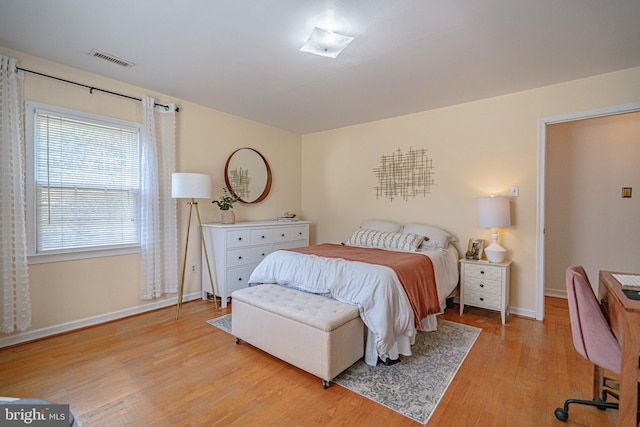 bedroom featuring visible vents, light wood finished floors, and baseboards