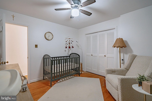 bedroom with a closet, baseboards, ceiling fan, and wood finished floors