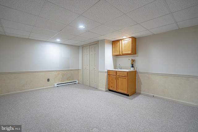 bar featuring a paneled ceiling, a sink, light carpet, and baseboard heating