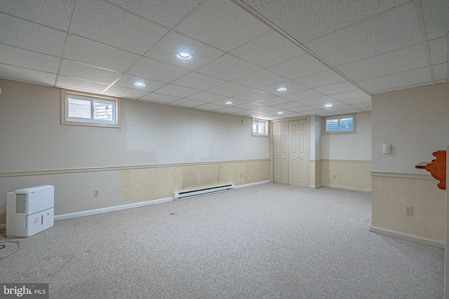 below grade area featuring carpet floors, baseboard heating, a wainscoted wall, and recessed lighting