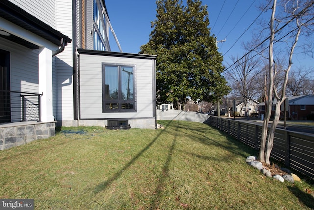 view of yard featuring central AC and fence