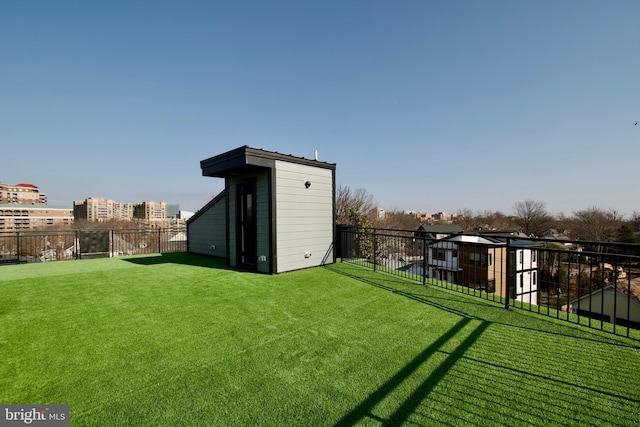 view of yard featuring fence, an outdoor structure, and a storage unit