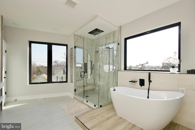 bathroom featuring visible vents, a freestanding bath, and a stall shower