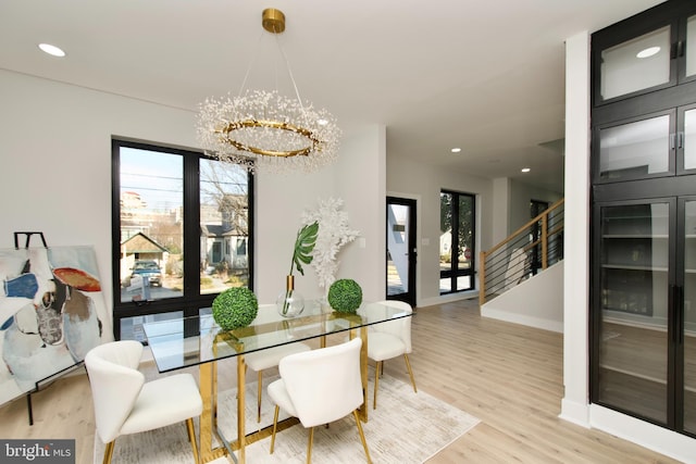 dining room featuring an inviting chandelier, stairs, recessed lighting, baseboards, and wood finished floors