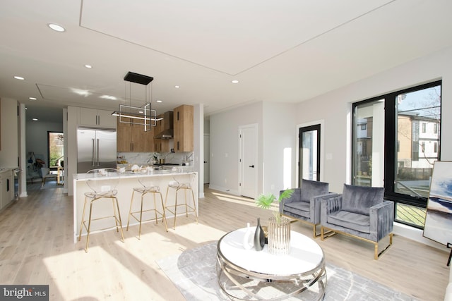 living room with recessed lighting, attic access, and light wood-type flooring