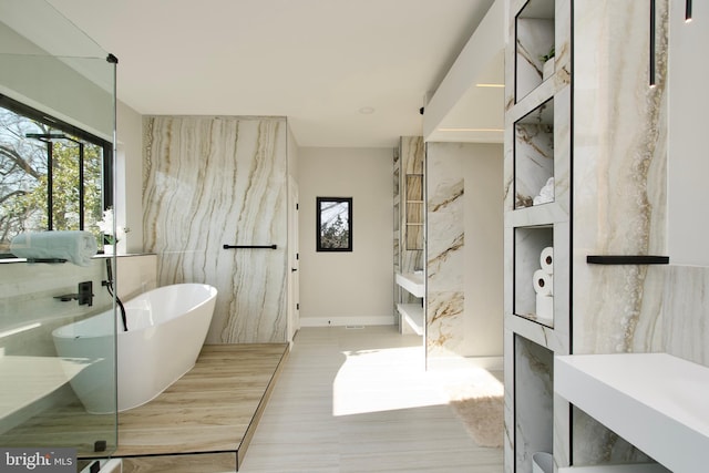 full bath featuring a soaking tub and wood finished floors
