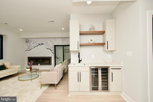 living area featuring recessed lighting, light wood finished floors, wine cooler, and wet bar