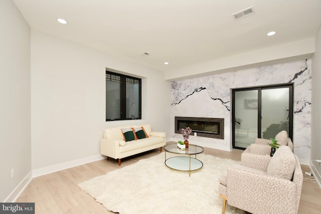 living area with baseboards, recessed lighting, wood finished floors, and visible vents