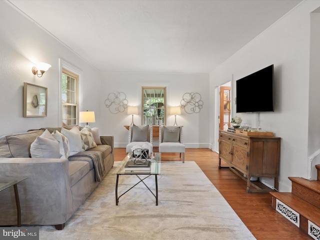 living room with wood finished floors, stairway, and baseboards