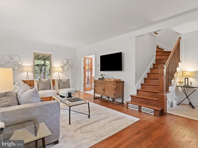 living area with hardwood / wood-style floors and stairway