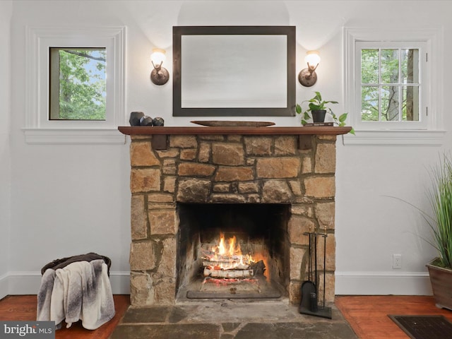 detailed view of wood finished floors, a fireplace, and baseboards