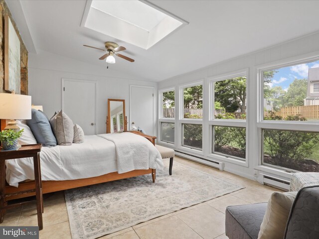 bedroom with a baseboard radiator, lofted ceiling, and light tile patterned floors