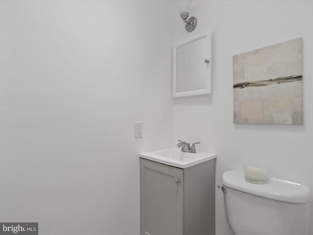 half bath featuring vanity and toilet