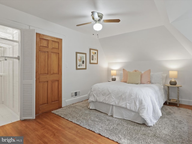 bedroom featuring wood finished floors, baseboards, vaulted ceiling, and ceiling fan
