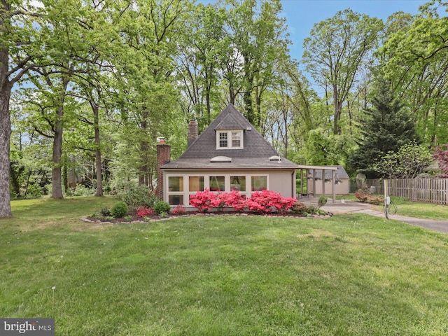 view of front of home featuring driveway, a chimney, and a carport