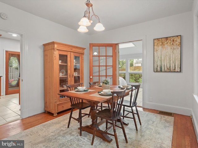 dining area with light wood-style floors and baseboards