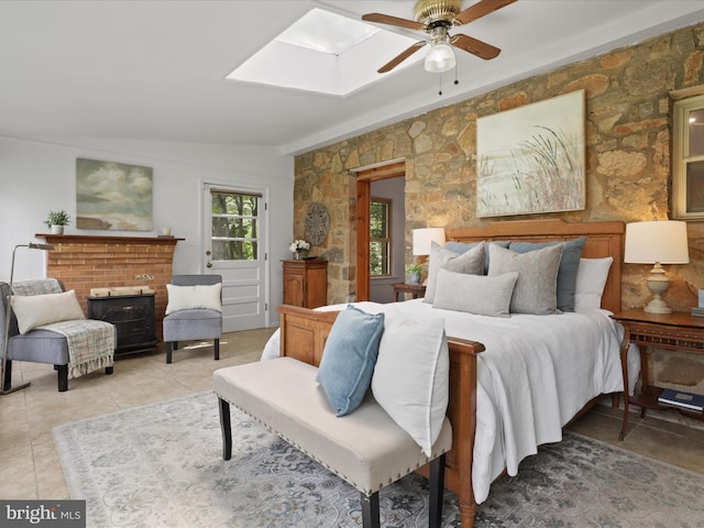 bedroom featuring light tile patterned floors, a skylight, and a ceiling fan