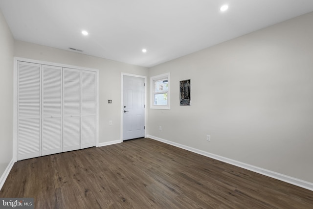 unfurnished bedroom featuring recessed lighting, baseboards, a closet, and dark wood finished floors