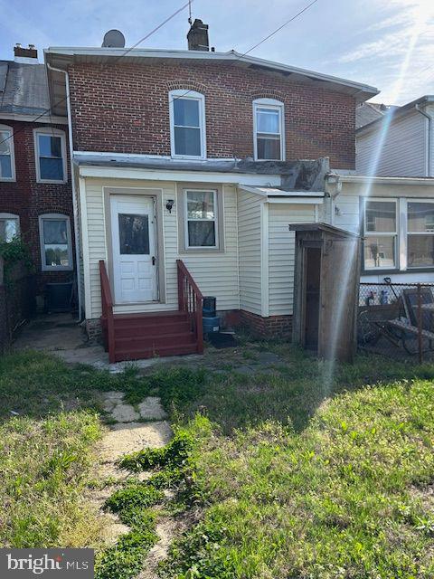 rear view of house featuring fence and entry steps