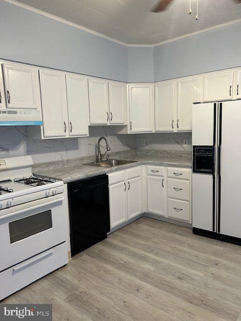 kitchen featuring crown molding, white appliances, white cabinetry, under cabinet range hood, and a sink