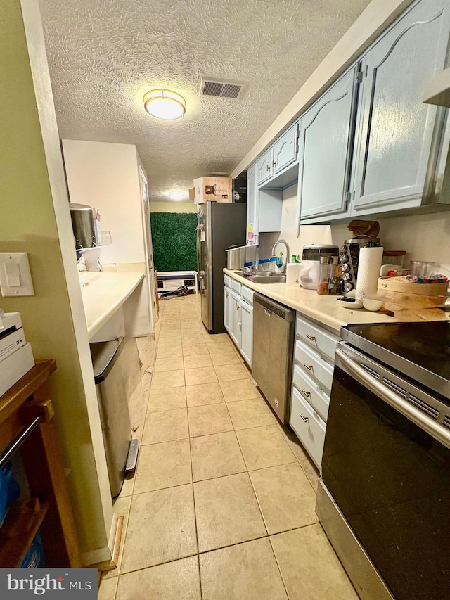 kitchen with a sink, light countertops, stainless steel appliances, and visible vents