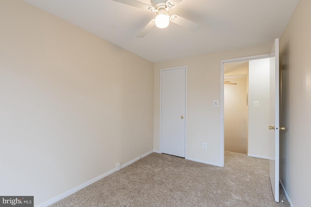 unfurnished bedroom with light colored carpet, baseboards, and ceiling fan