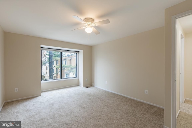 spare room with visible vents, baseboards, ceiling fan, and carpet floors