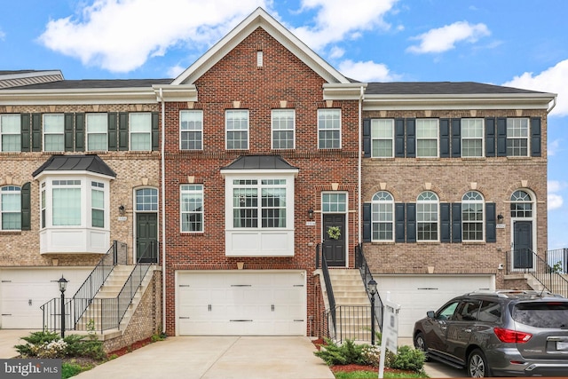 townhome / multi-family property featuring an attached garage, stairs, and brick siding