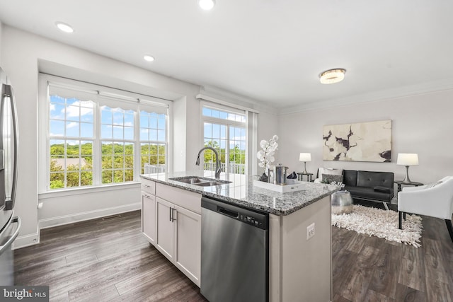 kitchen with light stone countertops, a sink, dark wood finished floors, stainless steel dishwasher, and a center island with sink