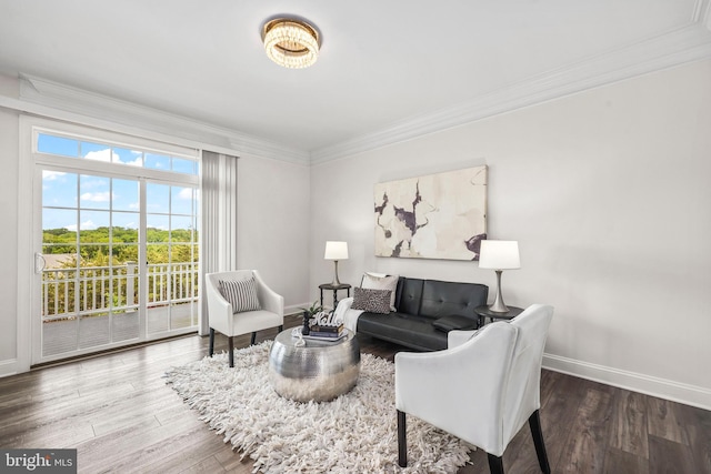 living area with crown molding, baseboards, and wood finished floors