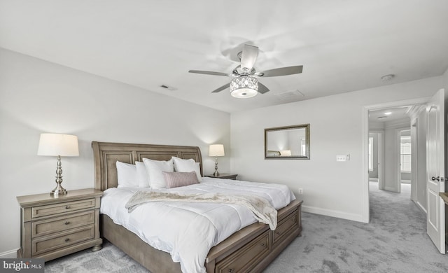 bedroom featuring light colored carpet, baseboards, visible vents, and a ceiling fan