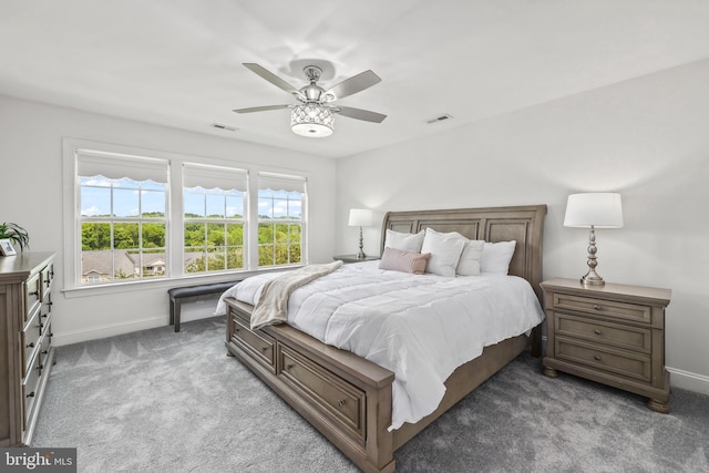carpeted bedroom featuring baseboards, ceiling fan, and visible vents
