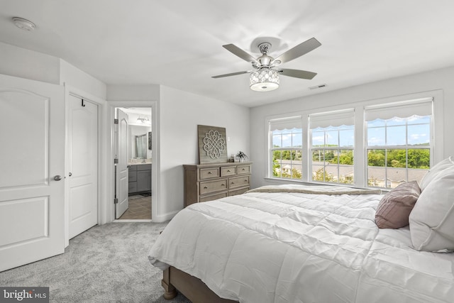 bedroom featuring light colored carpet, connected bathroom, ceiling fan, and visible vents
