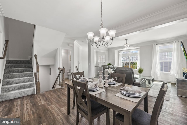 dining room featuring crown molding, dark wood-style flooring, stairway, and ceiling fan with notable chandelier